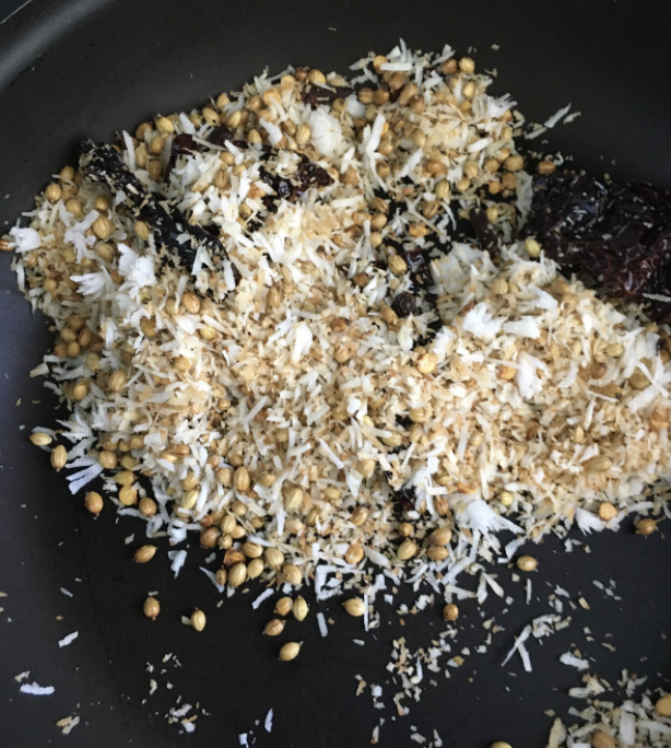 Cool the mixture. Add remaining coconut, haldi powder, and tamarind